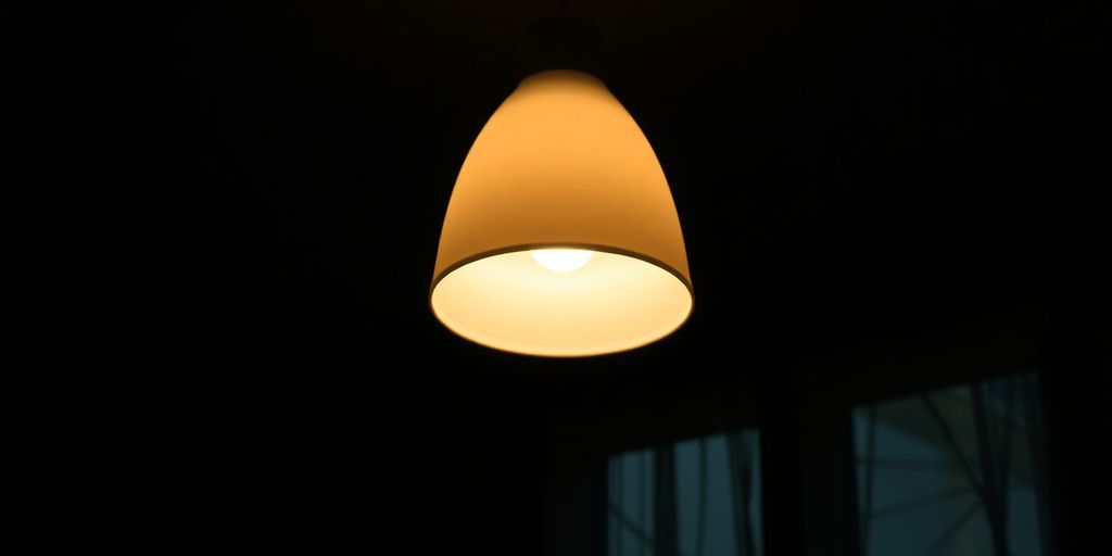 Light fixture emitting soft, diffused light in dim space.